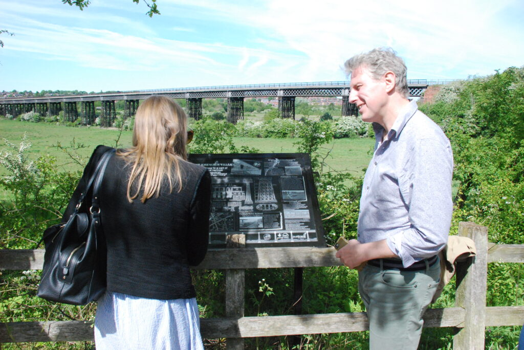 Two officers from the World Monument watch read the interpretation panel at the viaduct viewing point on the Nottingham Canal.
