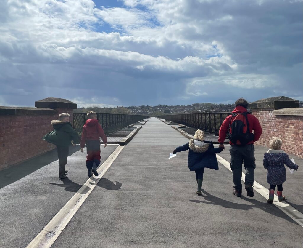 A family walking across the bridge.