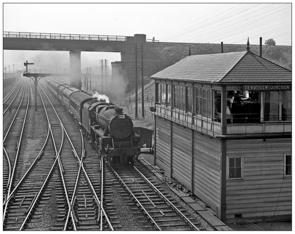 The signal box next to the viaduct with a locomotive travelling under the viaduct.